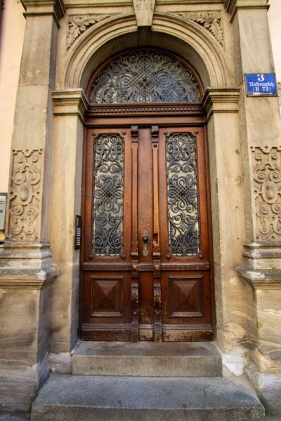 Богато украшенная деревянная дверь с красивой работой кованого железа. 1 Богато украшенная деревянная дверь с красивой работой кованого железа.